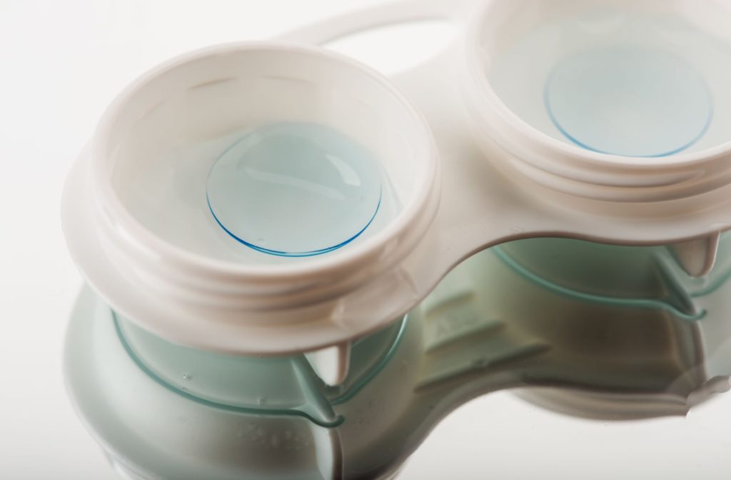 Hard contact lenses in a white container soak in with a solution