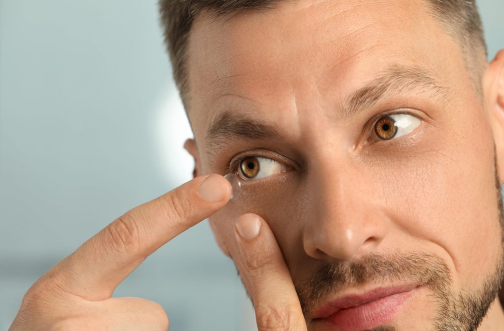 A man putting on a contact lens.