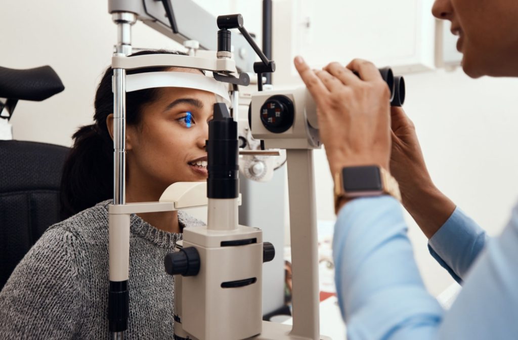 A woman has her eye examined with a slit lamp by an optometrist during a vision screening
