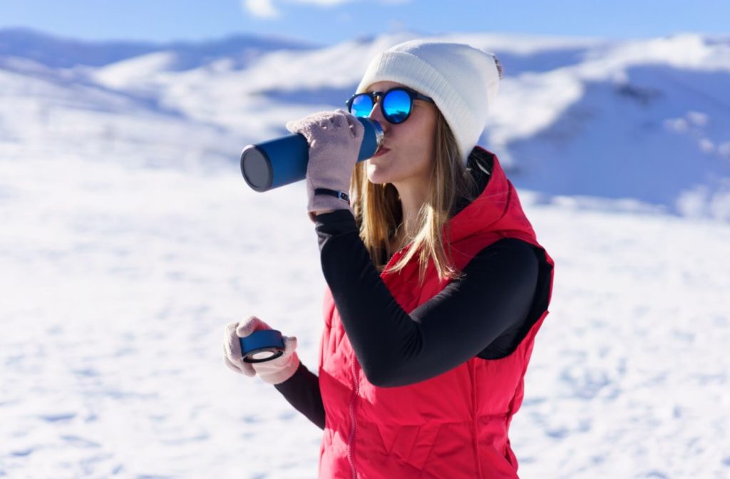 A young woman wears her polarized sunglasses while outdoors during the winter.