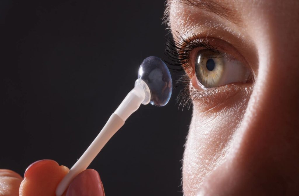 A person applying a scleral lens to the eye.