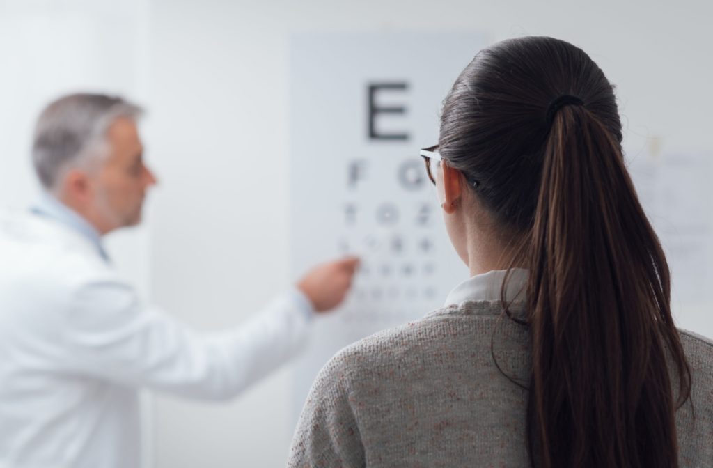 A patient focuses on reading the eye chart during their routine eye exam.