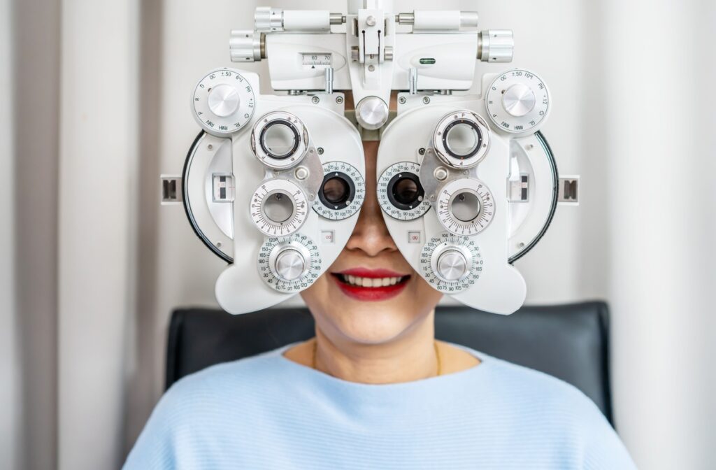 Person behind a phoropter, a mask like device with many knobs that go over a person's eyes.